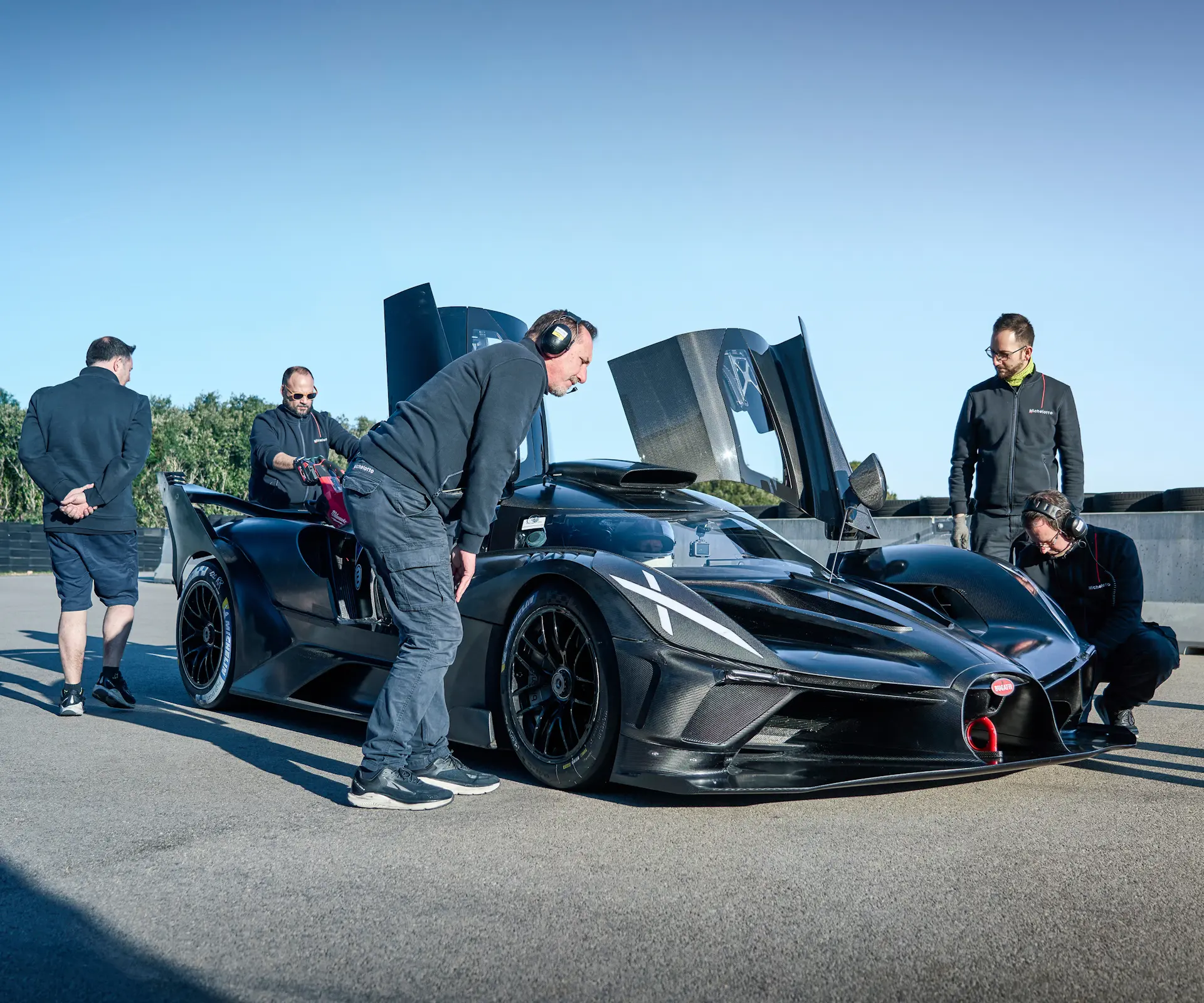 A set of mechanics & engineers prepare the bolide for a track session