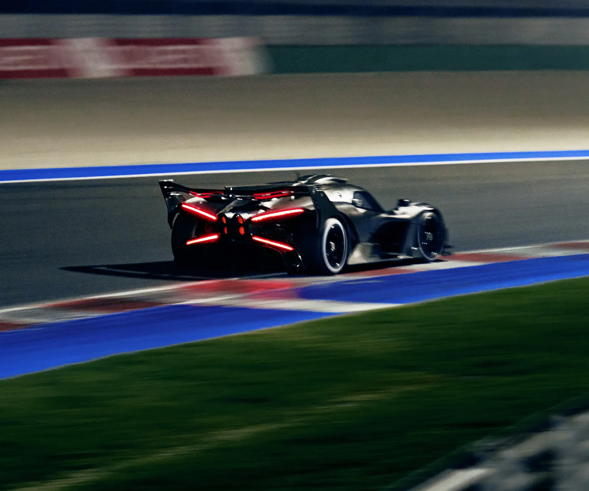 A bolide pictured from the rear while testing on a track in low dusk light